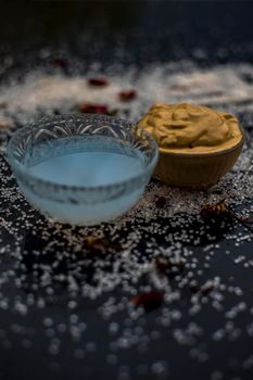 Ubtan/face mask/face pack of Multani mitti or fuller's earth on wooden surface in a glass bowl consisting of Multani mitti and coconut oil for the remedy or treatment of suntan.On the wooden surface.