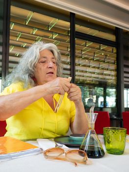 senior woman using chopsticks at the table asian restaurant outdoors