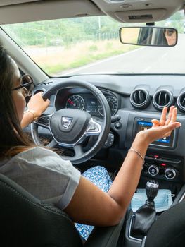 Beautiful business lady driving her car a cloudy day in summertime
