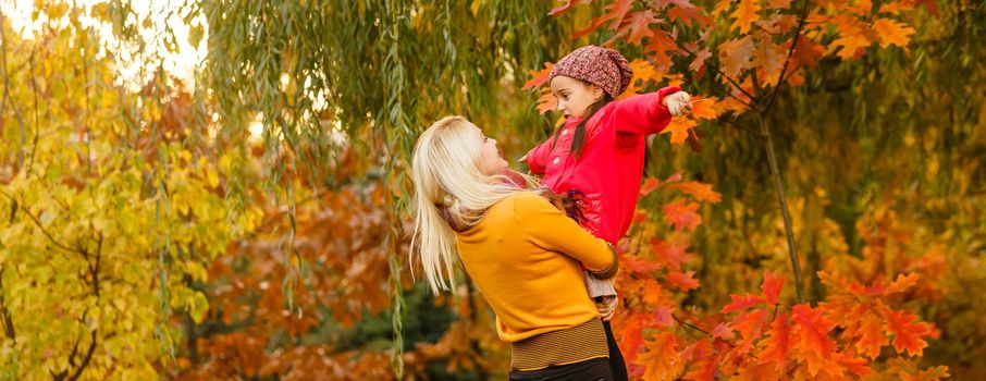 mother and her toddler girl have fun autumn