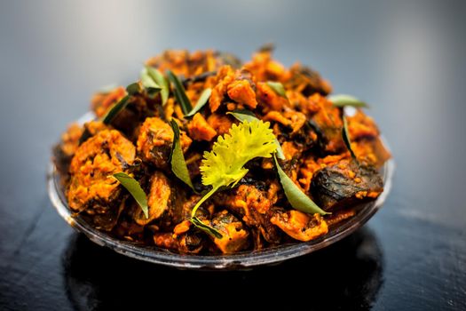 Famous Indian & Gujarati snack dish in a glass plate on wooden surface i.e. Patra or paatra consisting of mainly Colocasia esculenta or arbi ke pan or elephant ear leaves and spices.