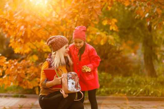 portrait of a young woman and her daughter in the autumn park