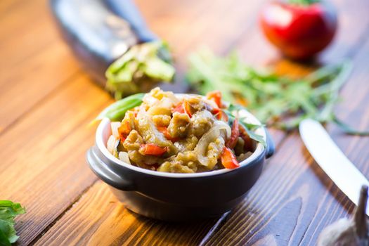 eggplant fried sauteed with other vegetables in a plate on a wooden table