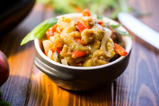 eggplant fried sauteed with other vegetables in a plate on a wooden table