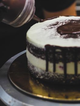 decorating a frosted cake with chocolate and nutella