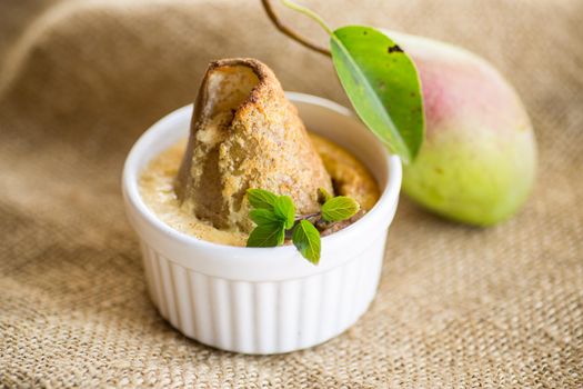 pear baked in curd dough in a small ceramic form, on burlap