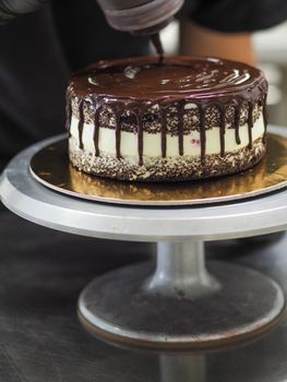 decorating a frosted cake with chocolate and nutella