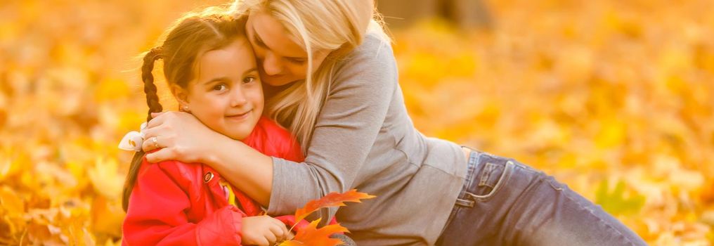 Mother with little daughter autumn park.