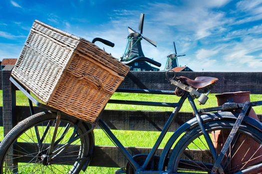 Bicycle with windmill and blue sky background. Scenic countryside landscape close to Amsterdam in Netherlands.