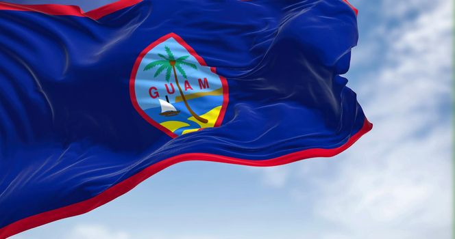 Flag of Guam waving in the wind on a clear day. Guam is an organized, unincorporated territory of the United States in the Micronesia subregion of the western Pacific Ocean