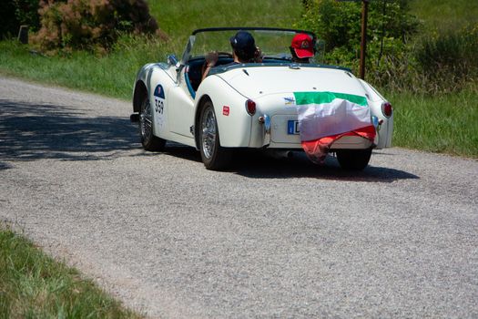 URBINO - ITALY - JUN 16 - 2022 : TRIUMPH TR3 SPORTS 1956 on an old racing car in rally Mille Miglia 2022 the famous italian historical race (1927-1957