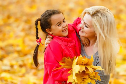 happy family mother with her daughter playing and laughing on autumn walk