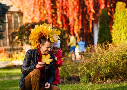 Happy family. daughter kissing and hugging her dad on a walk in the autumn leaf fall in park