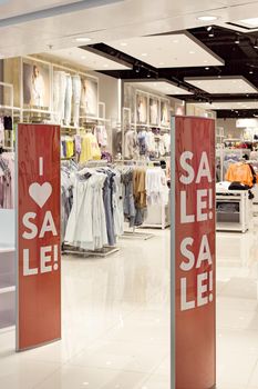 Sale sign on red entrance gates or sensor security panels of fashion shop clothing store, black friday sale shopping concept, seasonal offer promo, vertical image