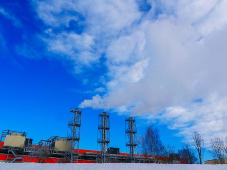 Air pollution in the city.Steam and smoke billows from smokestack at massive thermal power plant on a clear sky.