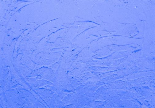 Blue abstract background..Beautiful blue textured plaster on the wall..Background from blue stucco..Streaks of paint on the wall.