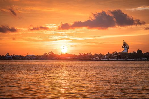 Silhouette of tree at sunset. Golden sun sunset reflect on surface of water nature background.