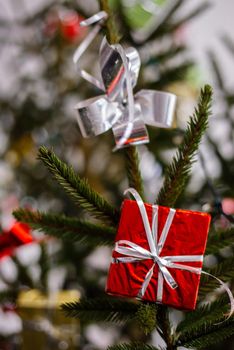 Red Glitter Mini Gift Box. A gift box and a white bow hangs on the Christmas tree.