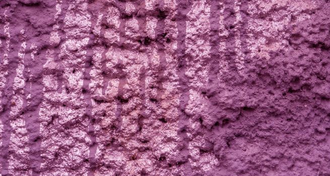 Old peeling paint on the wall..Magenta abstract background..Background from purple stucco.