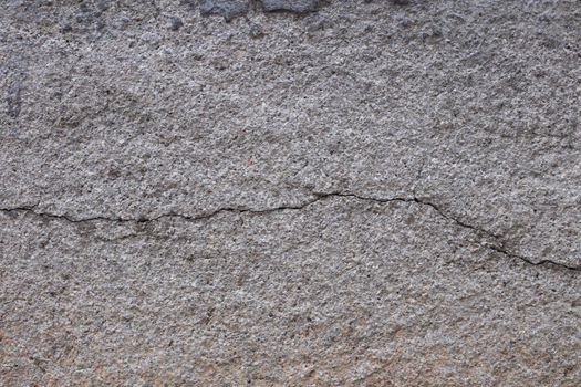 Old gray cracked stucco on the wall.