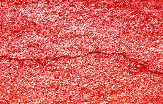 Cracked red stucco on a concrete wall. Red abstract background.
