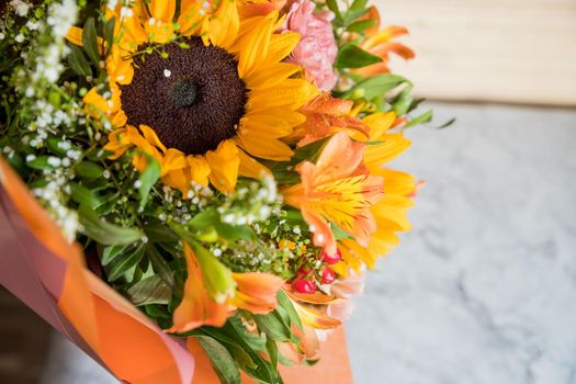 Hello August. Beautiful autumn bouquet with sunflowers and heart card close up on abstract light grey background.