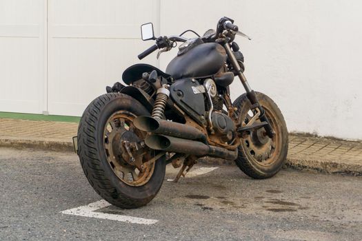 Classic old black motorcycle parked by the roadside