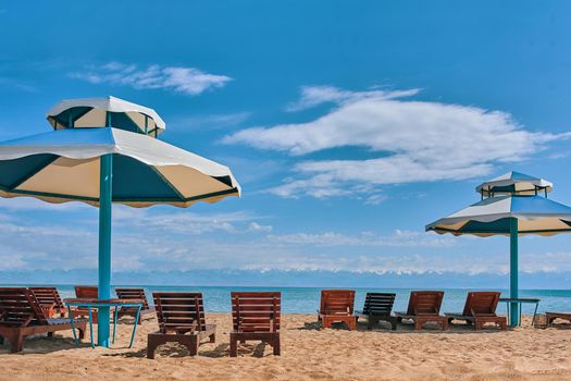 Sunbeds on the beach. Sun loungers with seats on the beach.