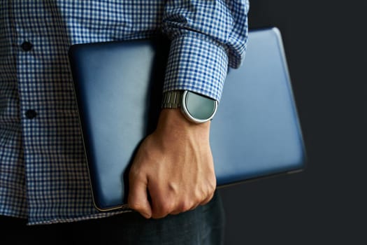 Laptop in hand. Notebook in arm with smartwatch.