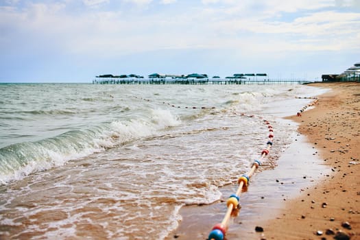 Sandy beach with waves from the sea. Vacation by the ocean in the hotel.