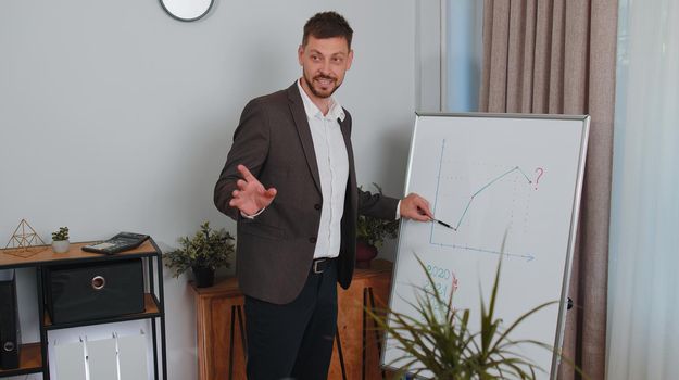 Businessman in formalwear suit holds online meeting presentation or training using a whiteboard at office. Marketing graph growth course. Financial strategy. Business increase. Freelancer business man