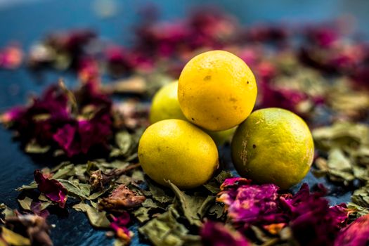 Neem or Indian Lilac face mask on the black wooden surface for oily skin consisting of neem leaves paste and lemon juice well mixed with rose water.
