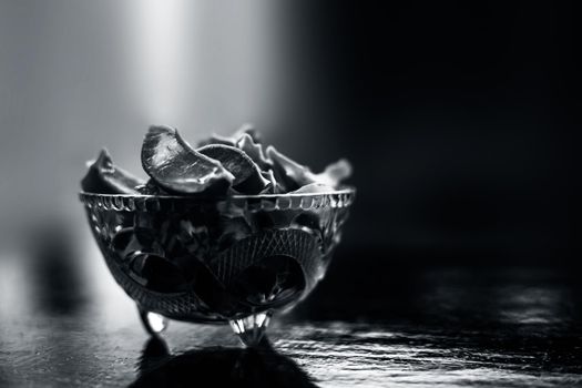 Raw cut aloevera or aloe vera gel in a glass bowl on wooden surface along with its reflection on the surface.