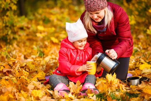 Mother daughter time. Soft focus shot of a mother and daughter reading a book together relaxing near the autumn park