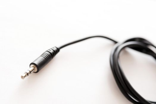 A black coloured audio lead with 3.5mm TRS jack plug on the end