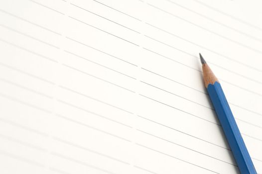 Sharp blue pencil on lined paper with space to place your message or text between the lines
