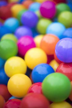 Colorful background of multicolored plastic balls in a ball pool with shallow dof in vertical format