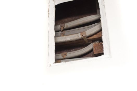 a hole cut into plasterboard to reveal acess to electrical mains cables