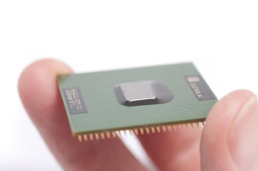 Macro view of fingers of person holding microchip, white background