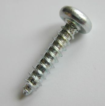 Metallic screw with helical ridge or external thread, high-angle close-up, with copy space on gray