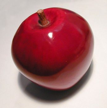 A decorative red ceramic apple on light background