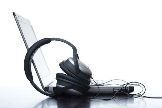 a pair of stereo headphones and a laptop computer - concept of digital audio recording
