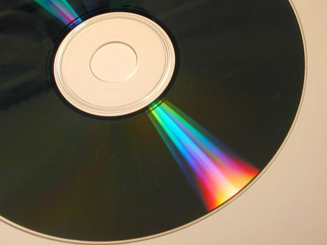 Iridescent bright colorful spectral shine on a CD or DVD disc in a close up view refracted into the colors of the rainbow