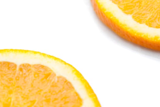 Partial view on a white background with copyspace between them of slices of fresh juicy orange citrus fruit showing the texture of the pulp