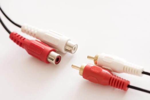 Plastic red and white RCA jack phono connectors disconnected from each other, close-up on white background