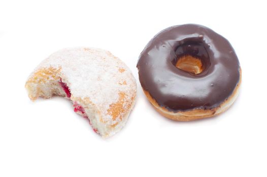 High angle view of a fresh chocolate ring donut and sugared jam doughnut broken open to expose the filling