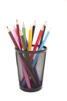Colored pencils in black pencil holder isolated on white