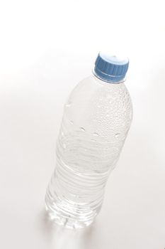 Empty unlabeled plastic water bottle with droplets still adhering to the sides in a healthy drinking and recycling concept