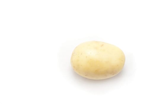 Single whole cleaned uncooked farm fresh potato on a white background with plenty of copyspace