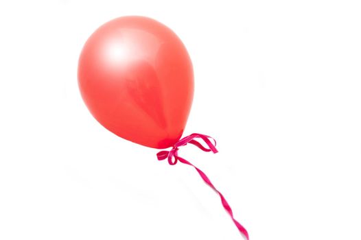a red balloon tied with a pink ribbon cut out on white